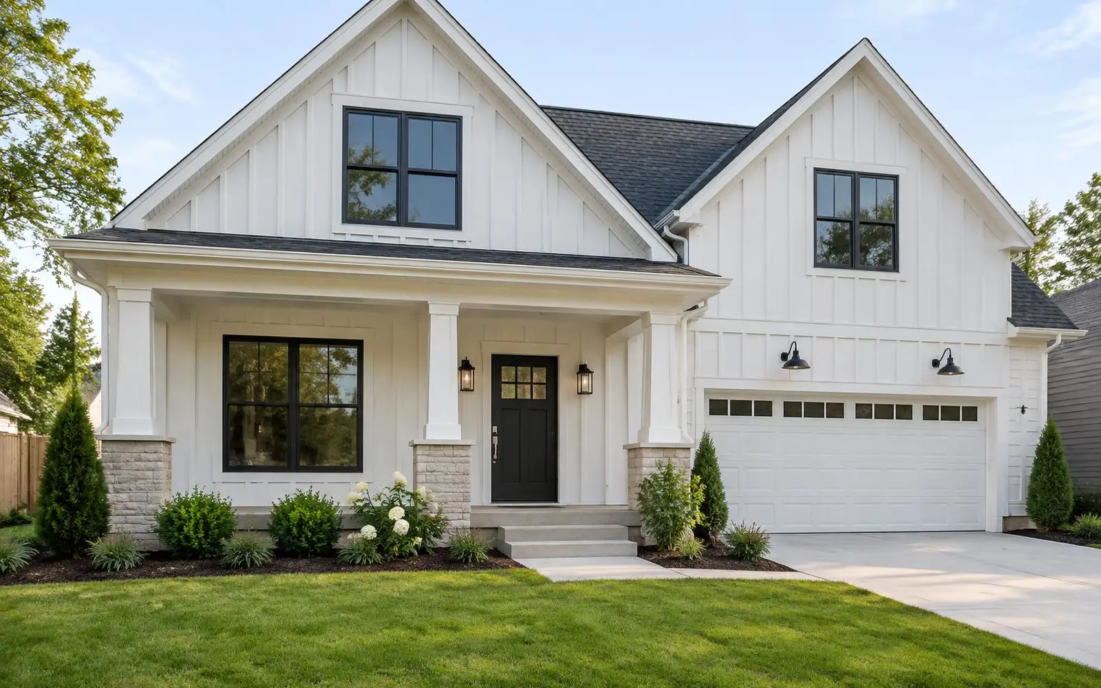 White house exterior with board and batten siding, black windows and a covered front porch
